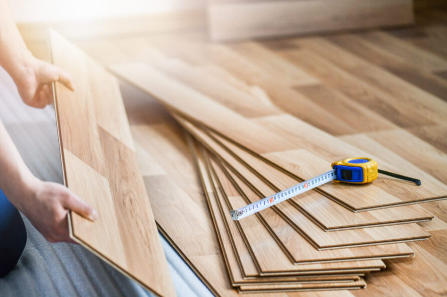 Man installing laminated wooden floor, Professional floor work in new house.